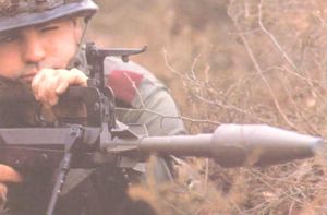 French soldier aims with the rifle grenade, mounted to the barrel of the FAMAS assault rifle.