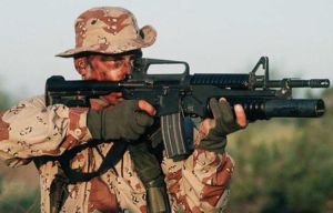 American soldier aims with the M4 carbine, combined with M203 underbarrel grenade launcher.