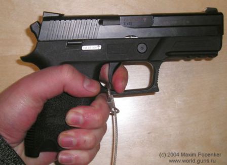 SIG-Sauer P250 DCc (compact) in the hand. Trigger is pulled partially, and the bobbed hammer is visible at the rear of the slide.