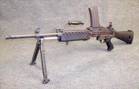 Stoner 63A weapon in magazine-fed light machine gun configuration, with longer and heavier barrel. Note that sights are offset to the left because of overhead magazine.