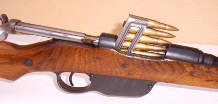 Steyr Mannlicher M95/30 rifle, with bolt open and loaded clip partially inserted into action; note how the bolt handle remains horizontal, as opposed to more common rotating bolt actions such as Mauser.